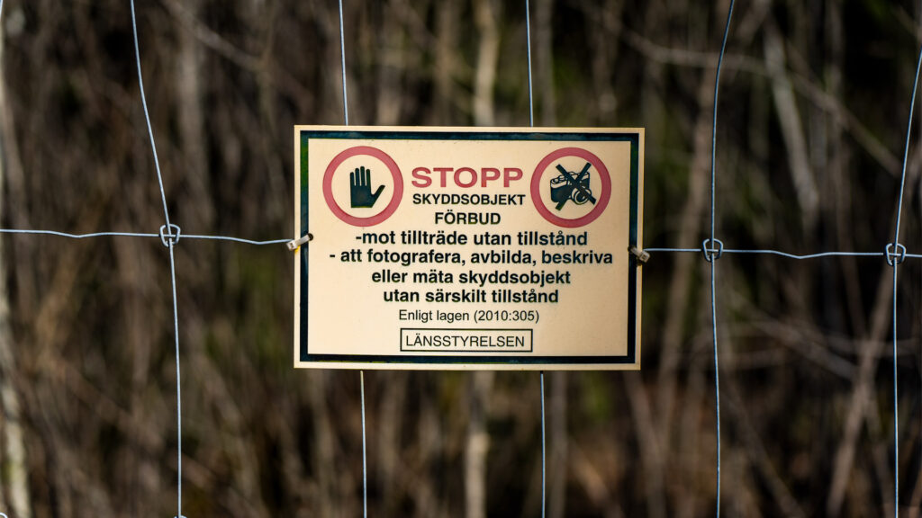 Skylt. STOPP Skyddsobjekt Förbud - mot tillträde utan tillstånd - att fotografera, avbilda, beskriva eller mäta skyddsobjekt utan särskilt tillstånd